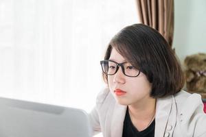 mujer adolescente trabajando en una laptop en la oficina en casa foto