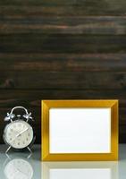 Mockup with golden frame and alarm clock photo