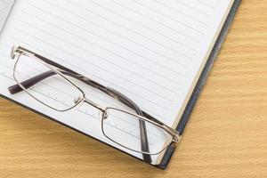 Notebook open blank page and Eyeglasses photo