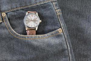 reloj de pulsera en el bolsillo de los pantalones vaqueros foto