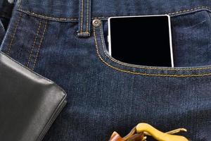 Wallet and smartphone on denim jeans photo