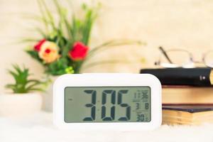 Digital clock with book decorated on table photo