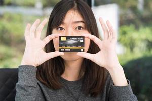 Close up young woman holding credit card photo