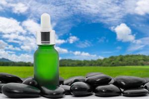 Serum oil bottle mock up with black stone and blue sky photo