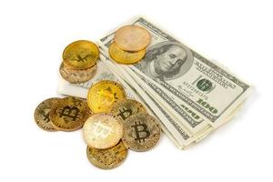 Golden Bitcoins of new digital money on banknotes of one hundred dollars. photo