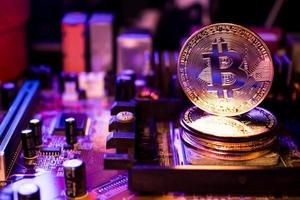Golden coins with bitcoin symbol on a main board computer. photo