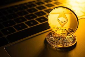 monedas de oro con símbolo de ethereum en la computadora. foto