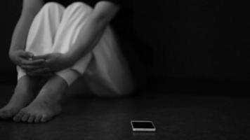 una donna che appoggia lo smartphone per terra ed è depressa video