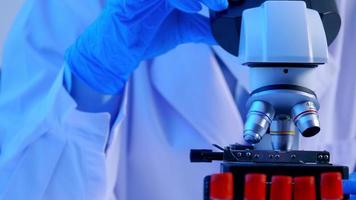 Asian scientist doing some research and looking through a microscope in laboratory. photo