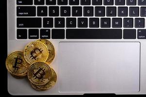 Golden coins with bitcoin symbol on computer. photo