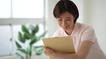 Image of a caregiver holding a binder and asking questions video