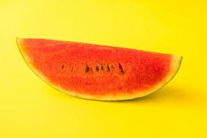 Fresh ripe watermelon slice on yellow background. photo