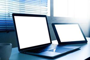 Blank screen laptop and tablet computer on the table photo