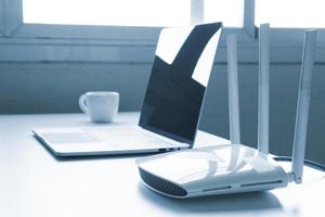 Laptop computer and router device on the table photo