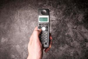 Close up of male hand press on button of an obsolete cellphone. photo