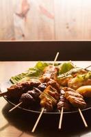 comida japonesa. yakitori carne marinada en salsa de brocheta y asada al carbón. foto