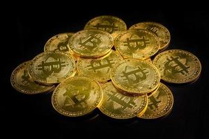 monedas de oro con símbolo de bitcoin en un fondo negro. foto