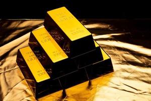 Stack of gold bars on shiny yellow background. photo