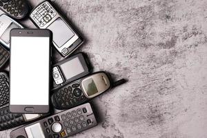 A smartphone on pile of obsoleted cellphones with a grunge background. photo