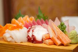 Sashimi japanese food. Sliced raw seafood on wooden plate. photo