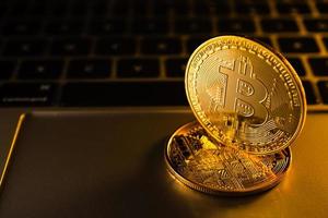 monedas de oro con símbolo de bitcoin en la computadora. foto