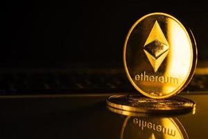 Golden coins with ethereum symbol on computer. photo