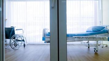 Bedroom for patient in a hospital, Empty bed and wheelchair on hospital ward. photo