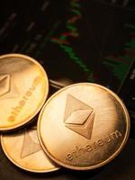 Ethereum coins with stock graph background. Digital currency concept. photo