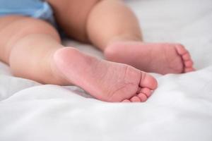 Close up of newborn baby feet on the bed. photo