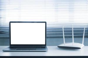 Blank screen laptop computer and router device on the table photo