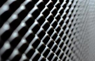 Focus and blurred of dark gray and silver grid of metal fence that taking as background. photo