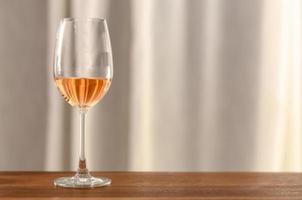 la copa de vino rosado en la mesa de madera foto