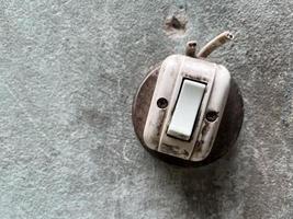 Old light power switch with tear electronic wire set on the wall. photo