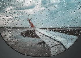 gota de lluvia en la ventana del avión antes de despegar cuando es temporada de monzones. foto