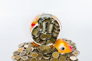 Broken piggy bank with Thai baht coins on white background. photo