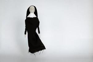 Scary nun ghost that no mouth flying up from the floor. Halloween minimal concept. photo