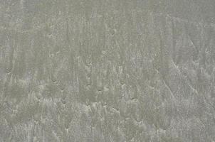 Background and texture photo of gray color wet sand.