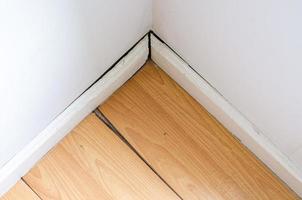 Parquet or wooden floor in the room with floor damaged by destructive elements from moisture or water. photo