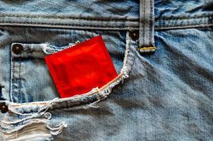 Condom in jeans pocket for safe sex, world sexual health and aids day concept. photo