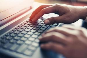 hombre de negocios que trabaja en el teclado de la computadora portátil hombre sentado en la mesa y usando la tecnología de Internet en el lugar de trabajo en la oficina - mano masculina escribiendo en el concepto de teclado foto