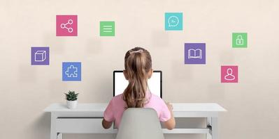 Girl surfs the internet on a laptop computer. The concept of using a computer for communication with friends, learning and safety on the Internet with hovering icons overhead photo