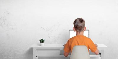 Boy typing on a laptop computer. The concept of sending an email or corresponding with friends. Protection of privacy of minors photo