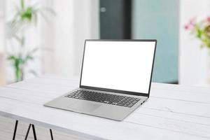 Laptop mockup on desk. Clean flat composition. Isolated display for web page mockup. Living room interior in background photo