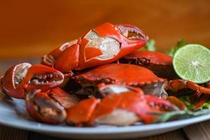 claw crab cooking food seafood plate with herbs spices lemon lime salad, fresh crab on white plate seafood sauce, boiled or steamed crab red in the restaurant photo