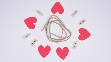 Stop motion red paper hearts fixed with clothespins on a cord. White background. Space for copy. video