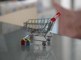 mini modelo de carrito de compras de supermercado colocado en una mesa de espejo con reflejo foto