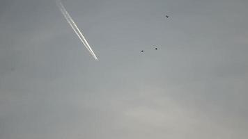 Jet airliner flying high in the sky leaves contrails in the clear blue sky. video