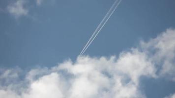 straalvliegtuig dat hoog in de lucht vliegt, laat contrails achter in de heldere blauwe lucht. video