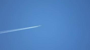 straalvliegtuig dat hoog in de lucht vliegt en contrails achterlaat in de heldere blauwe lucht. video