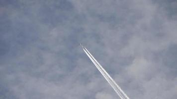 Düsenflugzeug, das hoch in den Himmel fliegt, hinterlässt Kondensstreifen am klaren blauen Himmel. video